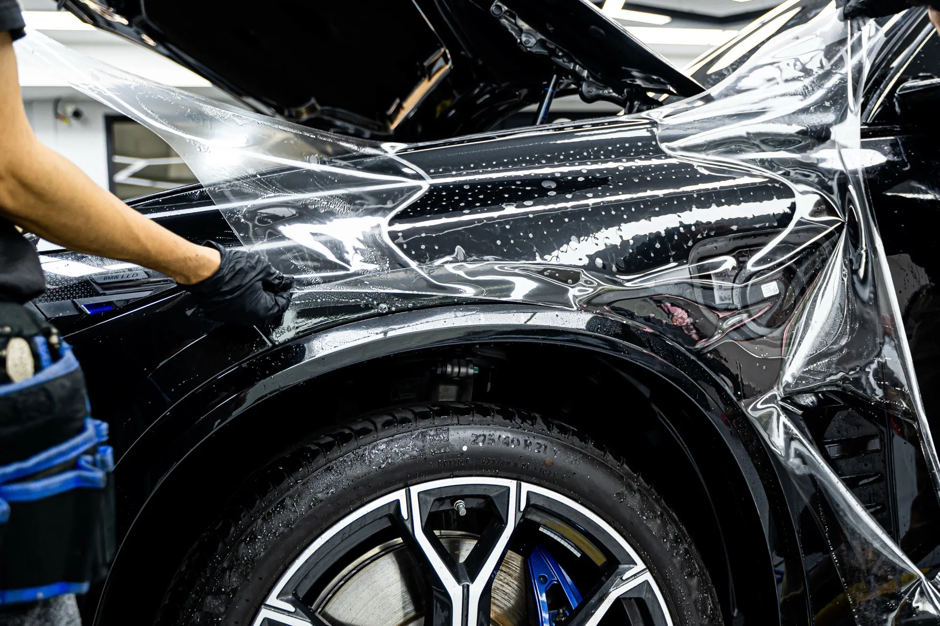 PPF-Lackschutzfolie wird nass am Kotflügel eines BMW verklebt